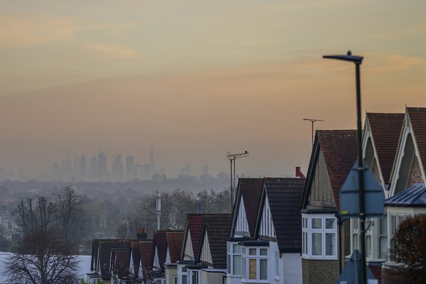 Distant skyscrapers and suburban houses on a misty dawn in London, UK