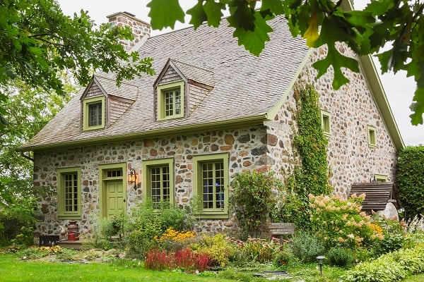 Exterior view of idyllic stone cottage with pretty garden in Canada.