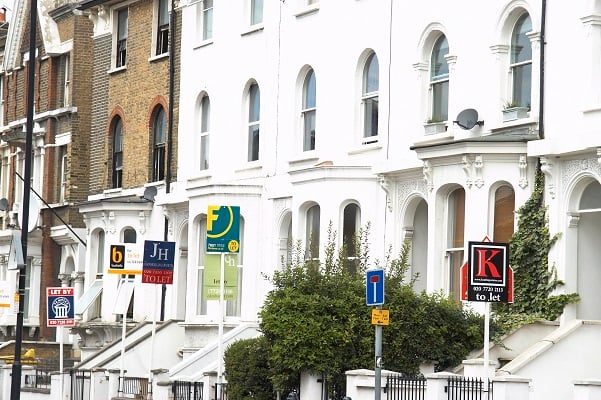 “Estate Agent boards in front of houses, London.”