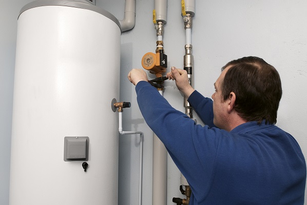 A plumber installing a boiler, UK.